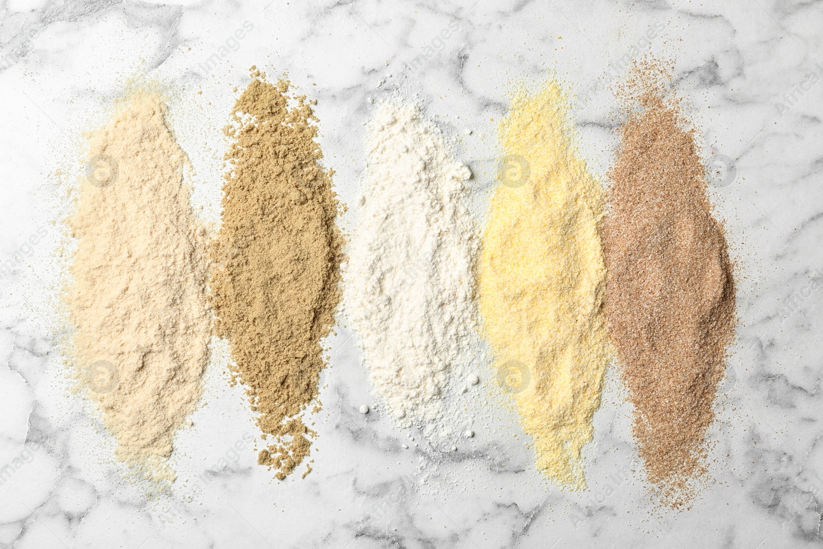 Photo of Stripes of different flour types on marble background, top view