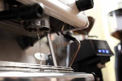 Photo of Water pouring from modern coffee machine, closeup. Space for text