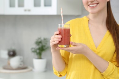 Photo of Woman with delicious smoothie in kitchen, closeup. Space for text