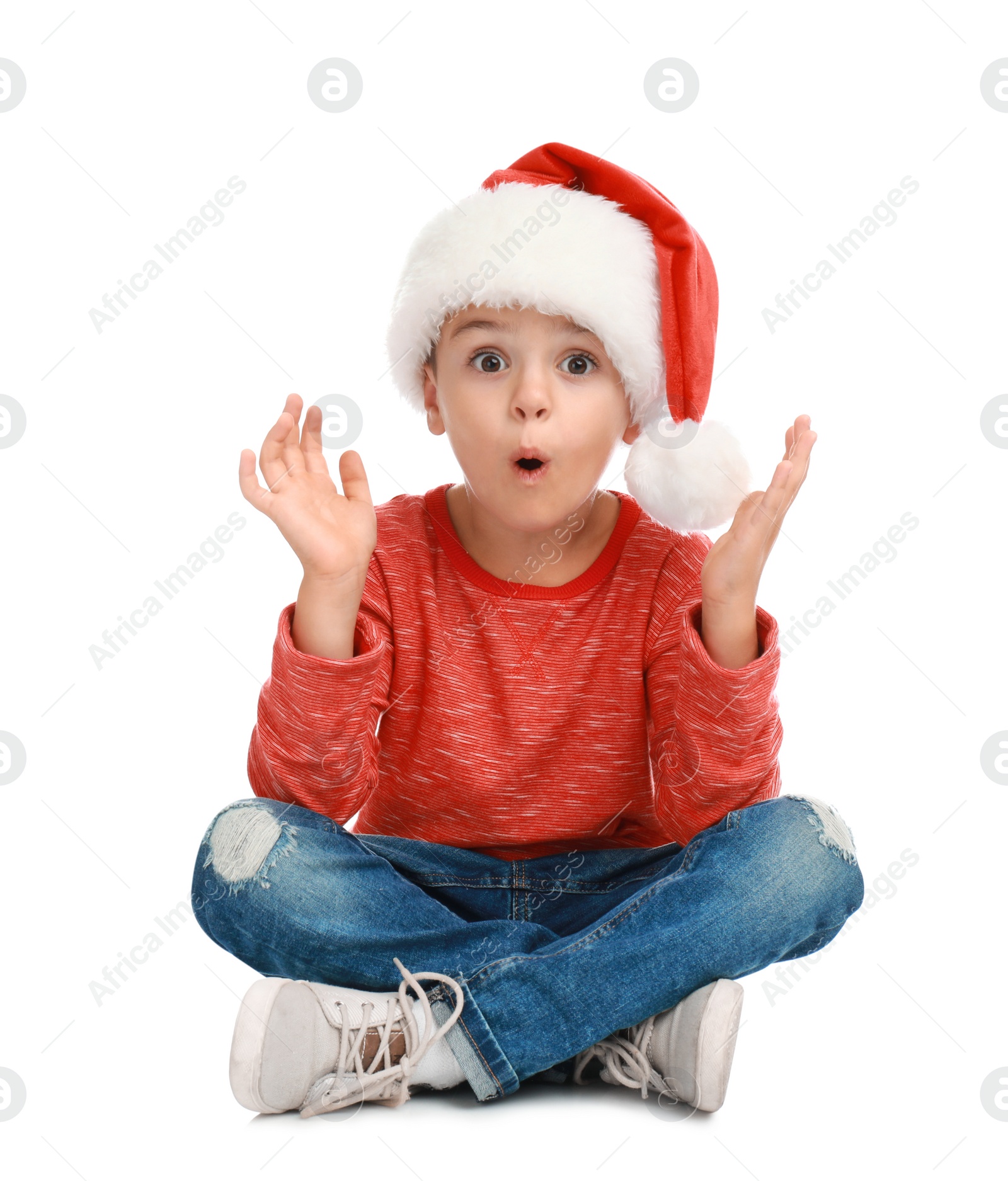 Photo of Cute little child wearing Santa hat on white background. Christmas holiday