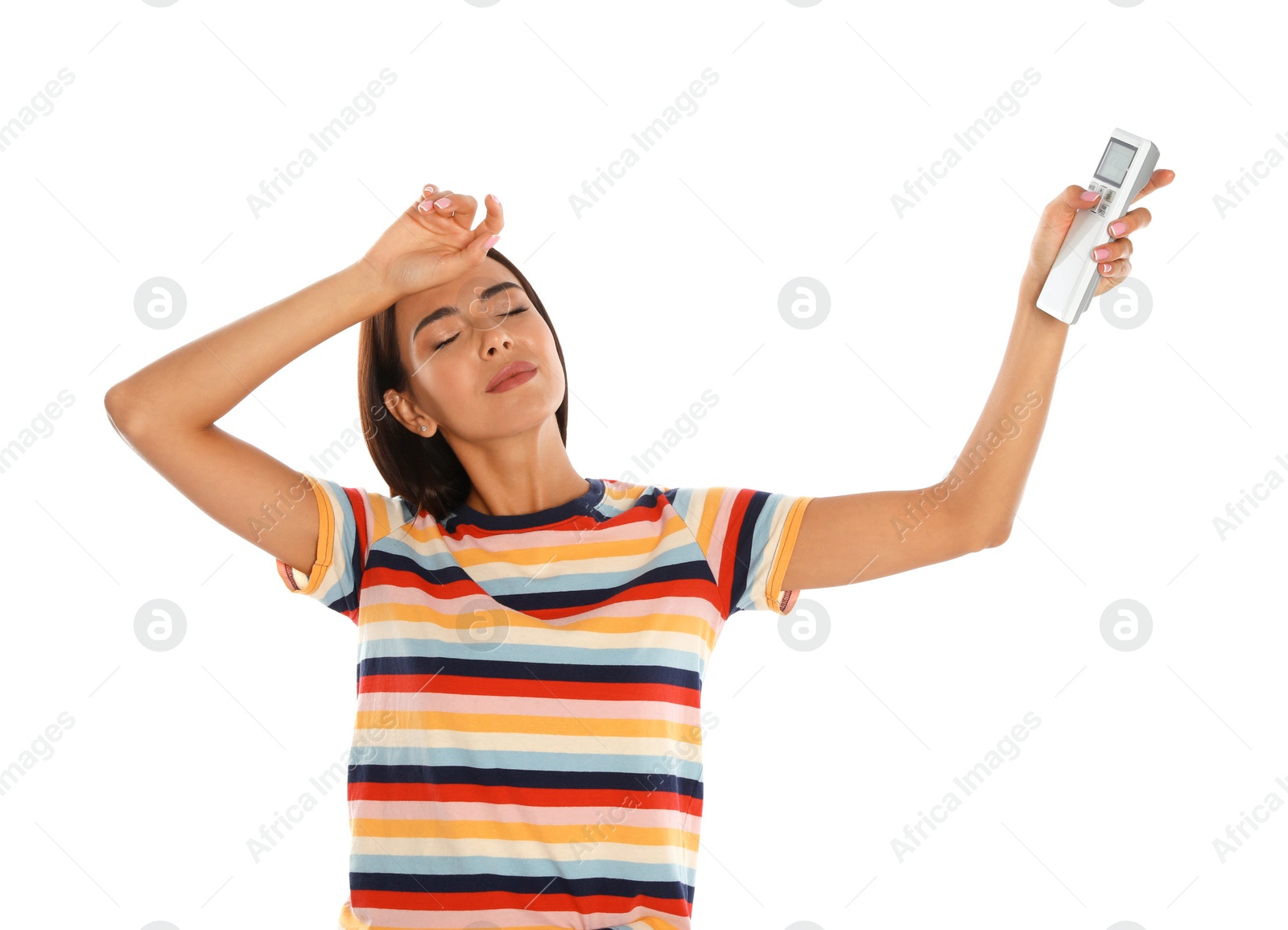 Photo of Young woman with air conditioner remote suffering from heat on white background