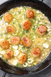 Photo of Fried scallops with sauce in dish on grey table, top view