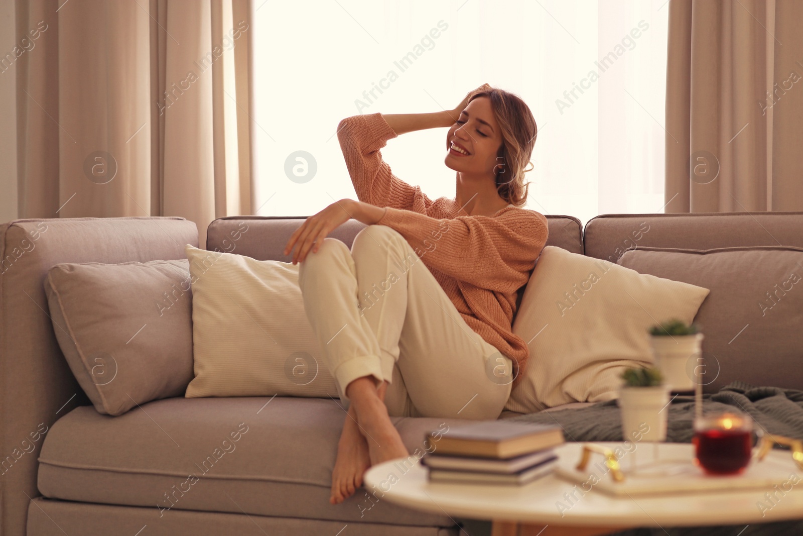 Photo of Beautiful young woman relaxing at home. Cozy atmosphere