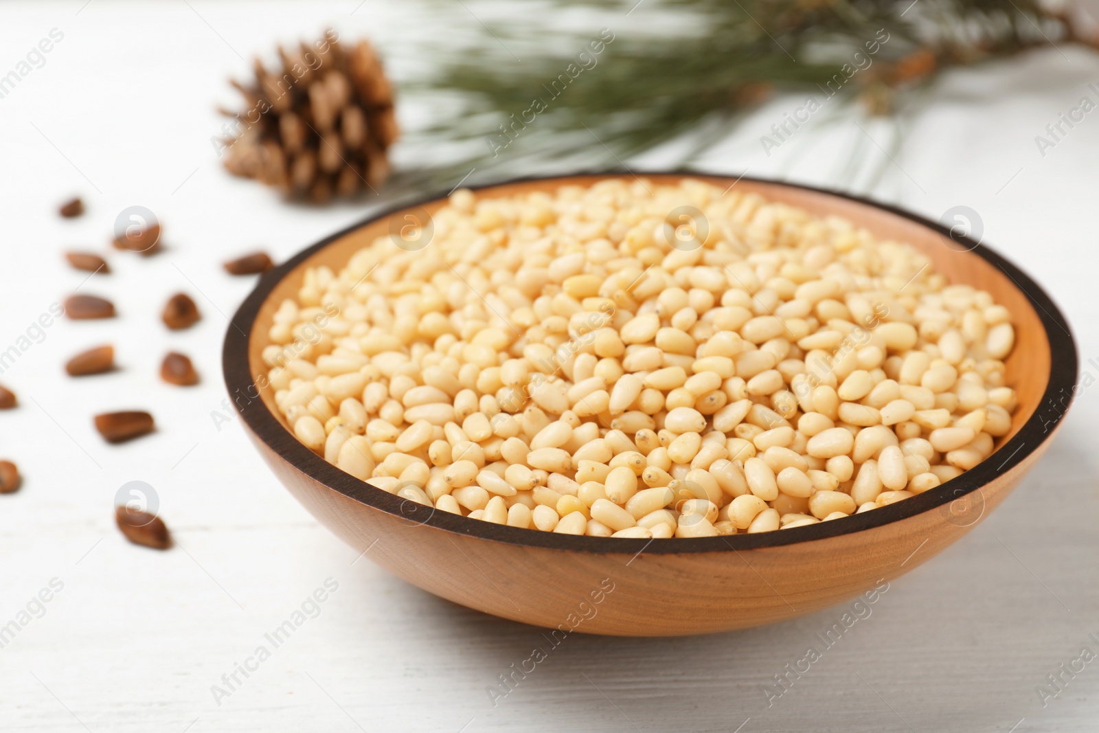 Photo of Plate with pine nuts on wooden table