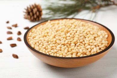 Photo of Plate with pine nuts on wooden table