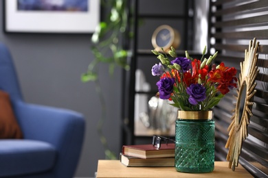 Glass vase with fresh flowers on wooden table. Space for text