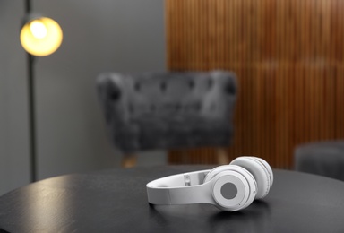 Photo of Stylish headphones on table indoors. Space for text