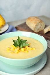 Photo of Delicious corn cream soup served on light grey table