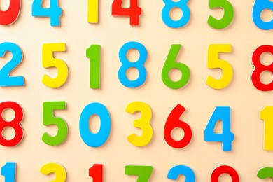 Colorful numbers on beige background, flat lay