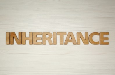 Word Inheritance made with letters on wooden background, flat lay