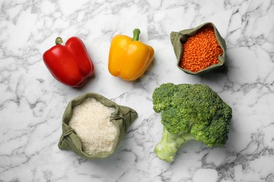 Photo of Fresh vegetables and seeds on white marble table, flat lay