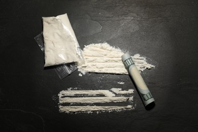 Photo of Drug addiction. Plastic bag with cocaine and rolled dollar banknote on grey textured background,, flat lay