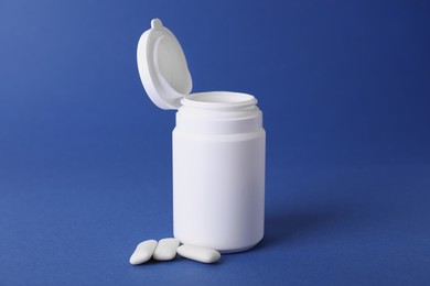 Photo of Jar with chewing gums on blue background