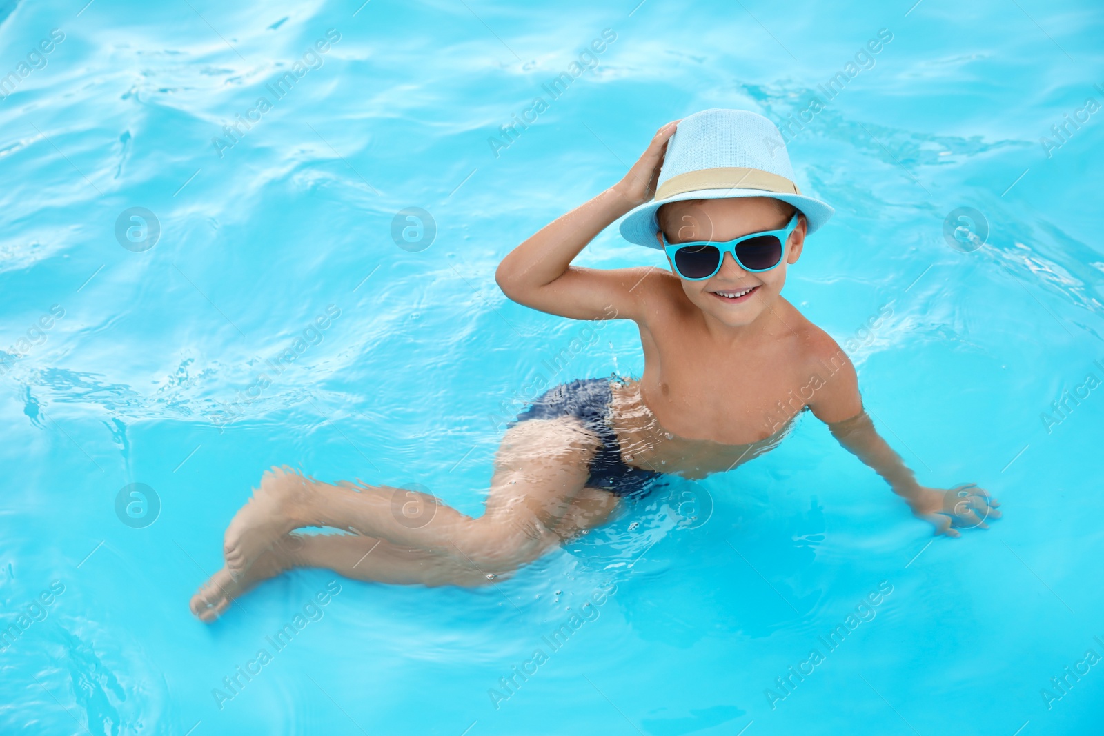 Photo of Cute little boy in outdoor swimming pool