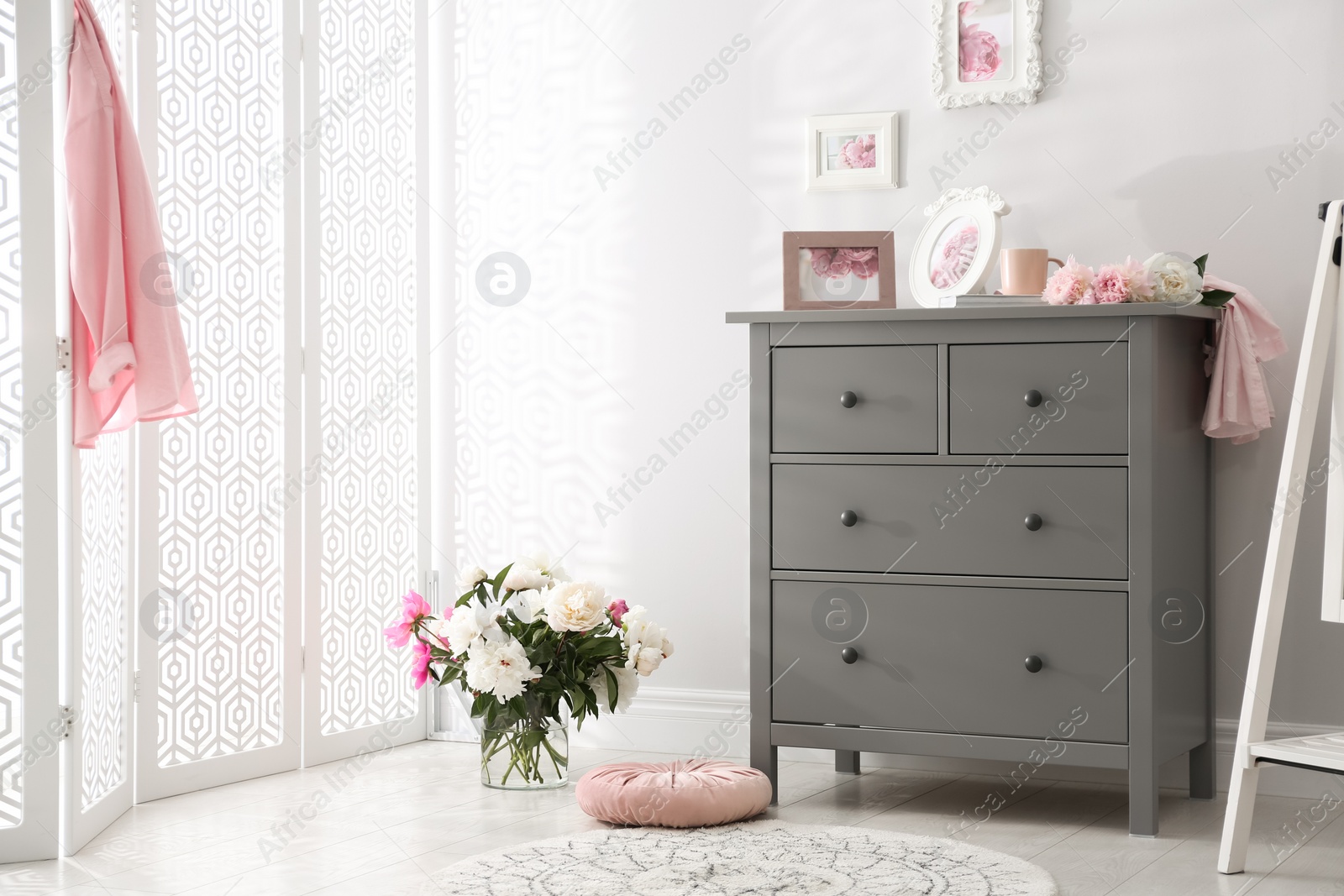 Photo of Grey chest of drawers in stylish room interior