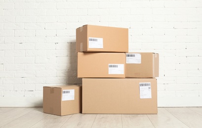 Stack of parcel boxes on floor against brick wall