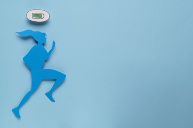 Photo of Woman's health. Female paper figure and battery symbol on light blue background, flat lay with space for text