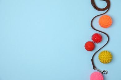 Flat lay composition with dog leash and toys on light blue background, space for text