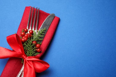 Photo of Cutlery set on blue background, space for text. Christmas celebration