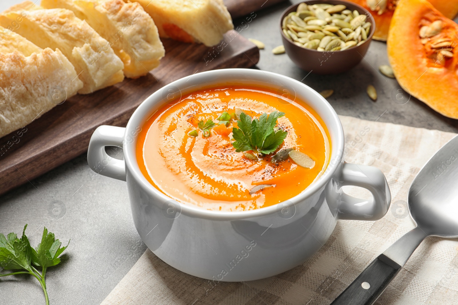 Photo of Bowl with tasty pumpkin soup served on table