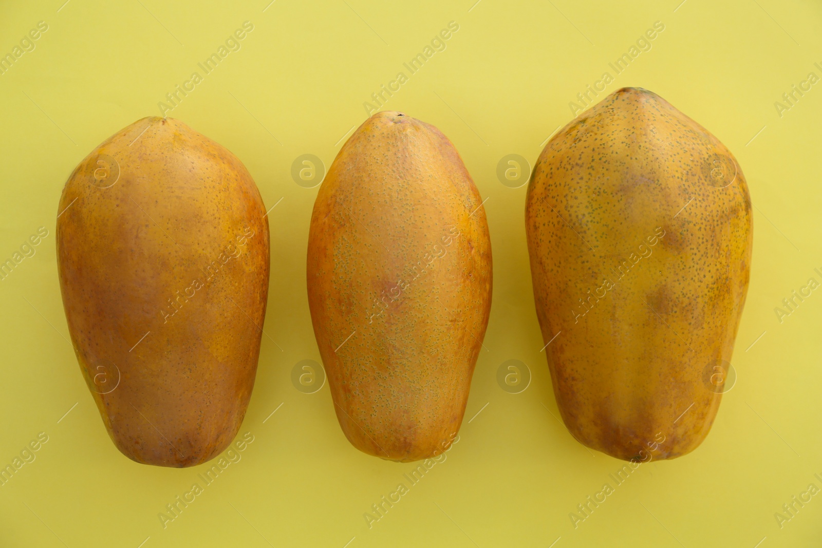 Photo of Fresh ripe papaya fruits on light green background, flat lay