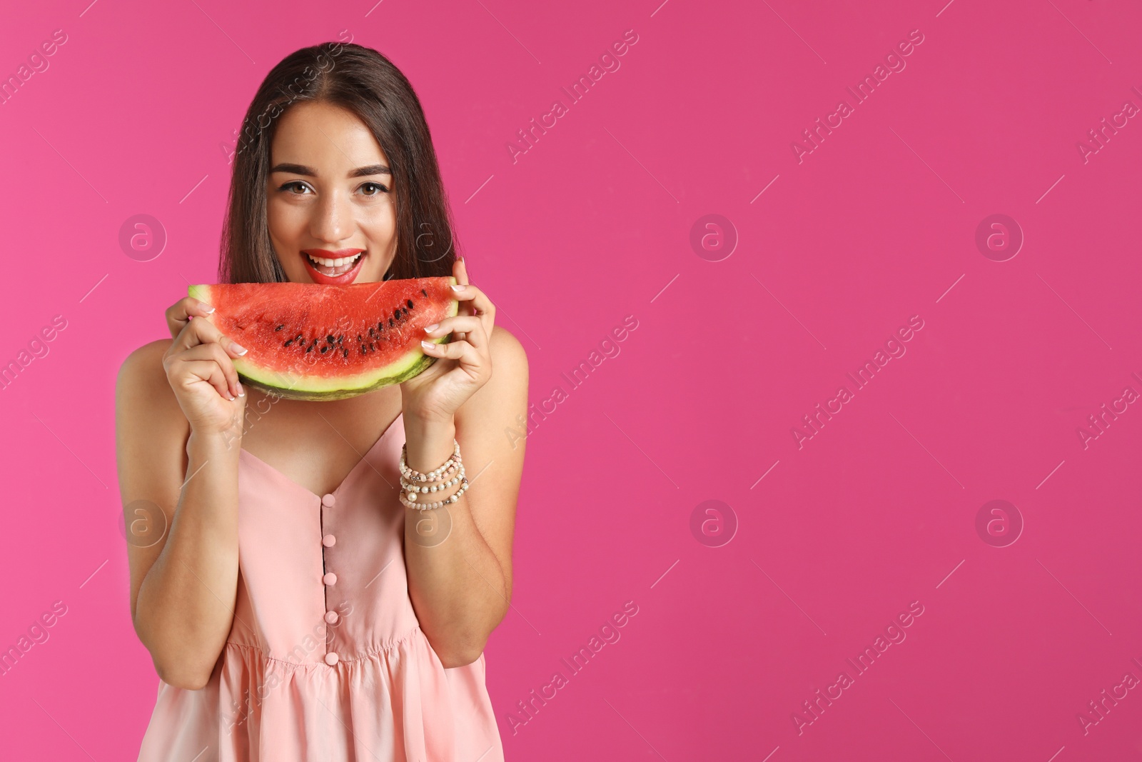 Photo of Beautiful young woman posing with watermelon on color background