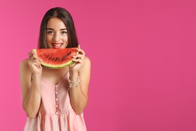 Beautiful young woman posing with watermelon on color background