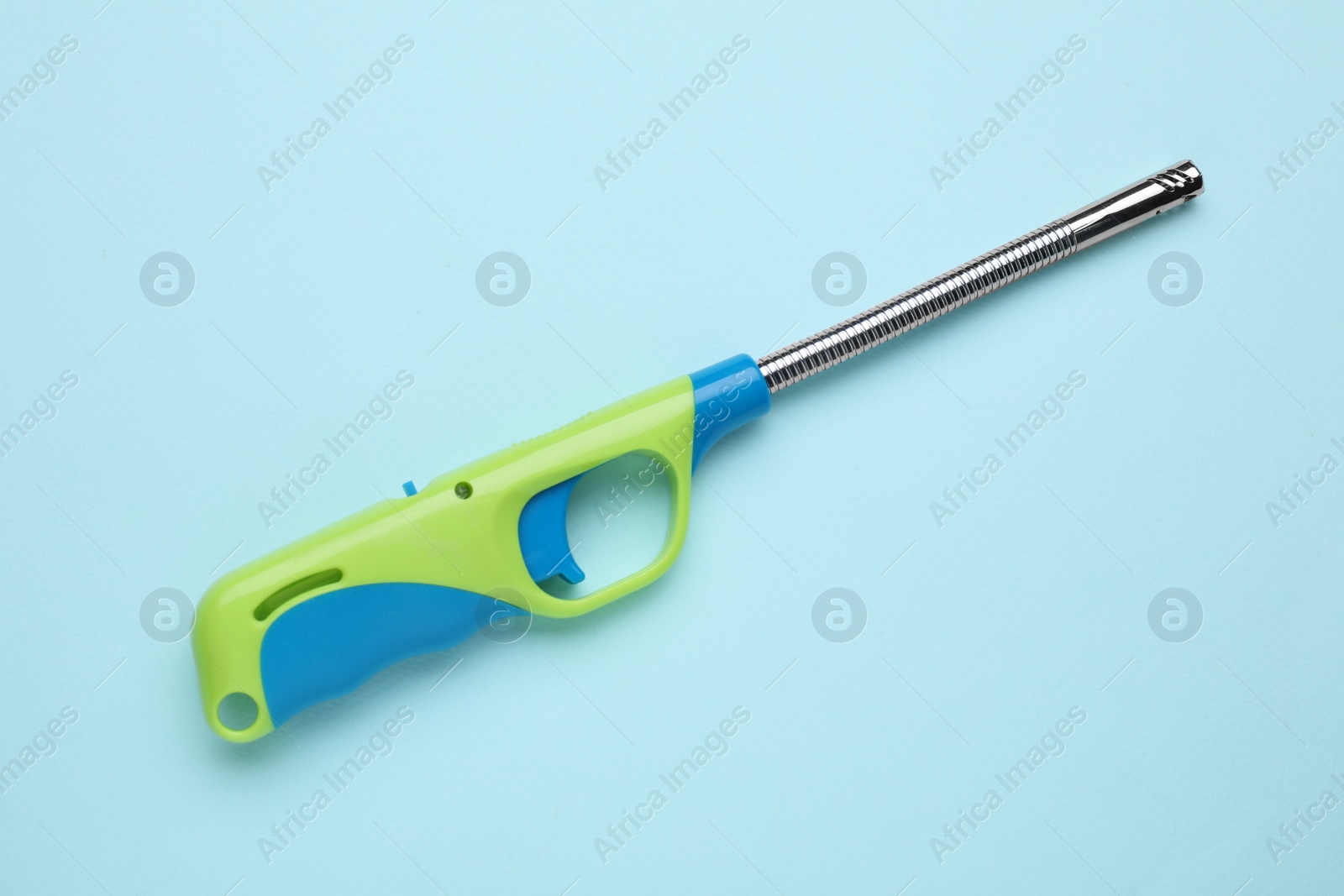 Photo of One gas lighter on light blue background, top view