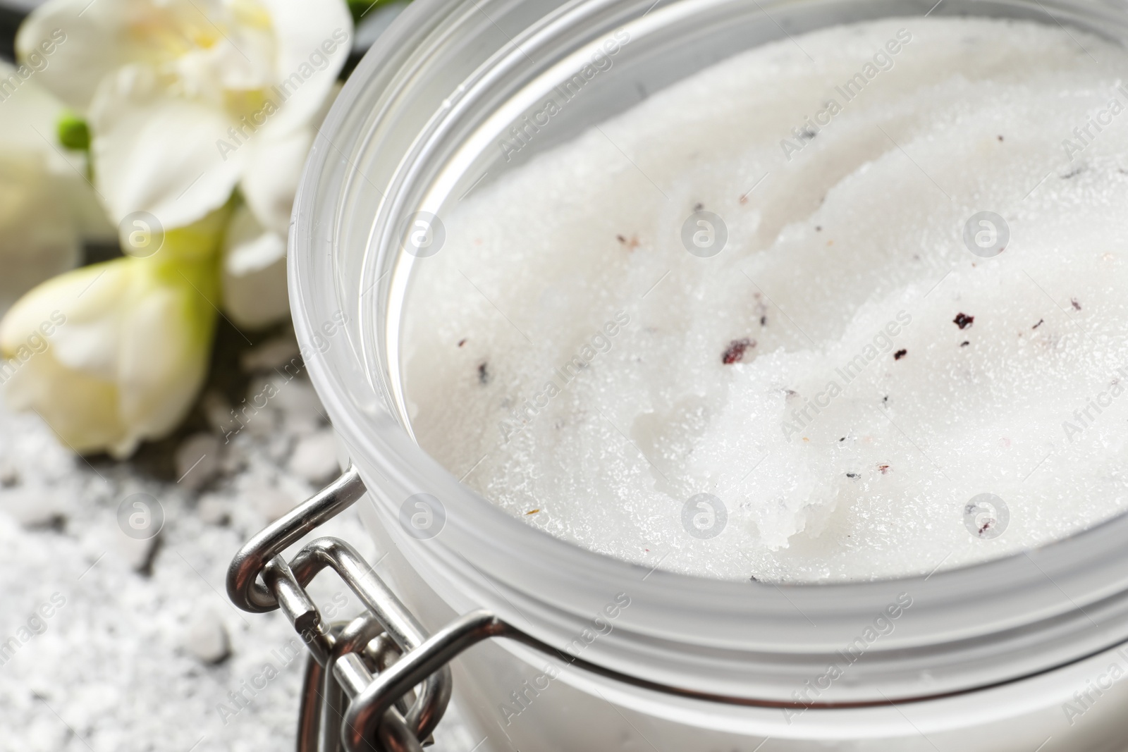 Photo of Body scrub in glass jar on table, closeup