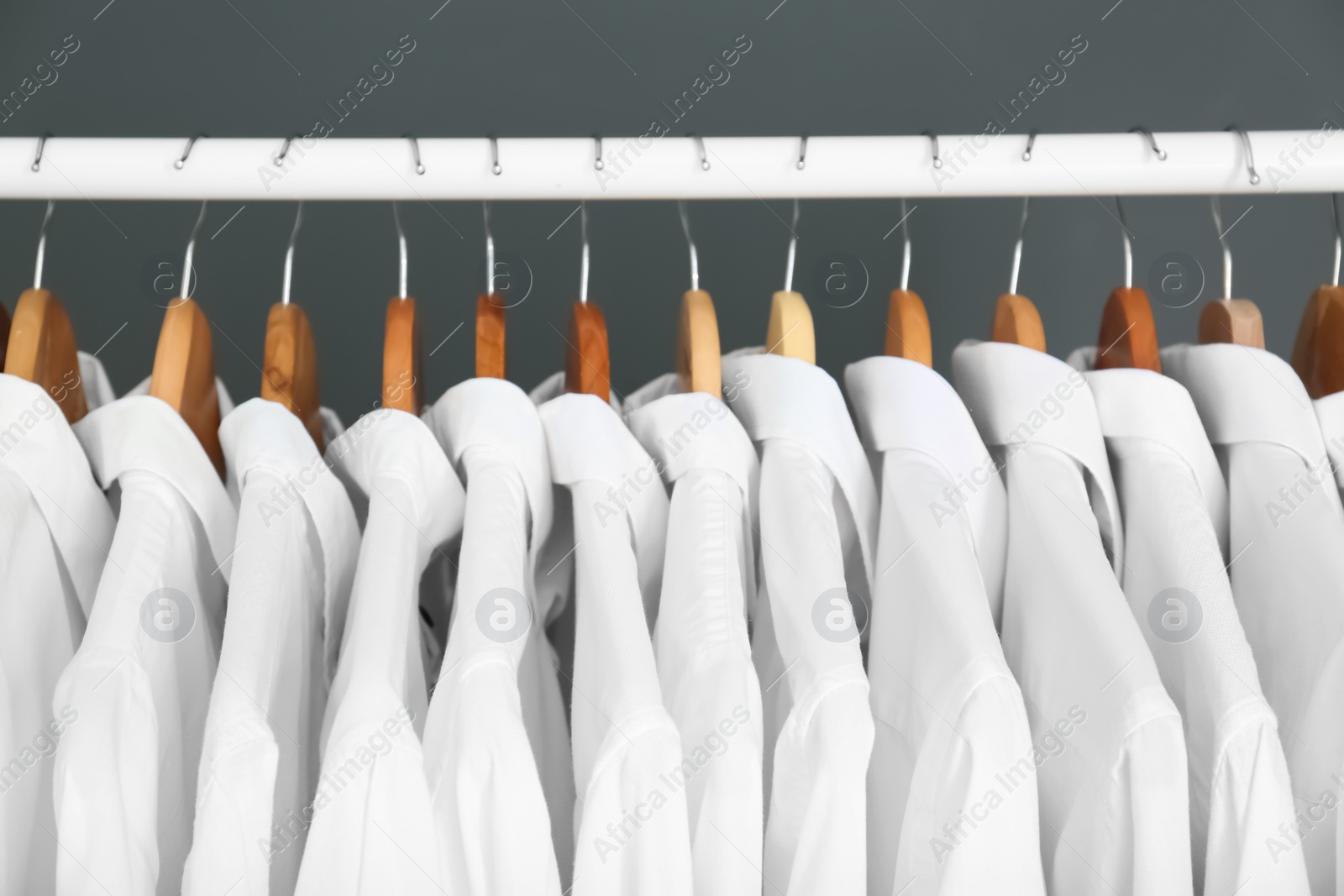 Photo of Rack with clean clothes on hangers after dry-cleaning