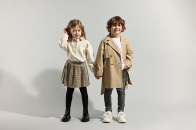 Photo of Fashion concept. Stylish children posing on light grey background