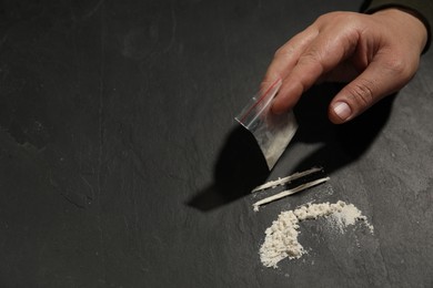Photo of Drug addiction. Man with cocaine at grey textured table, closeup. Space for text