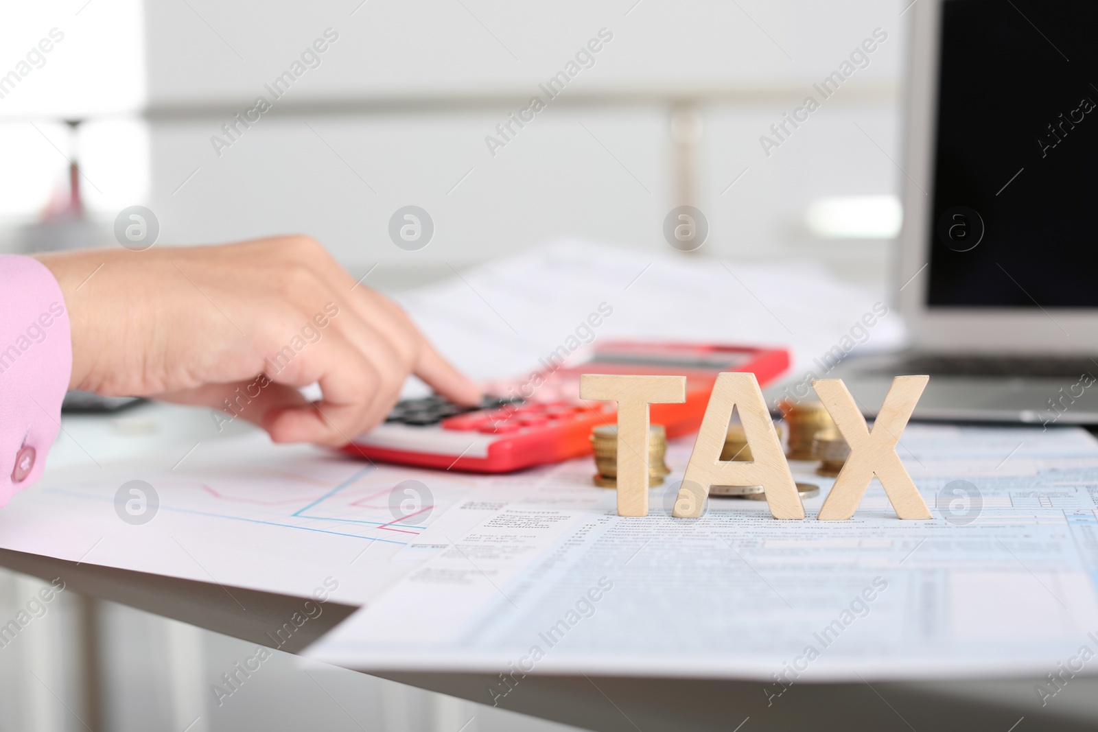 Photo of Young female calculating taxes at table, closeup