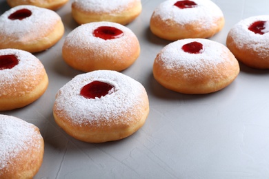 Photo of Hanukkah doughnuts with jelly and sugar powder on grey background, closeup