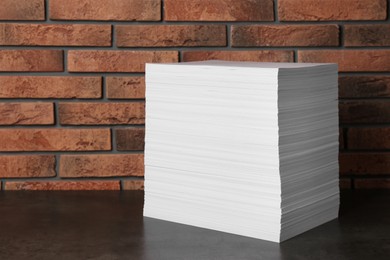 Photo of Stack of paper sheets on black table