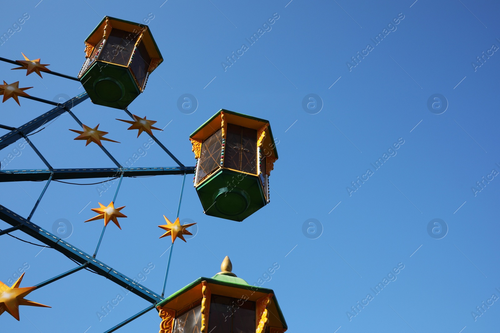 Photo of Beautiful large Ferris wheel against blue sky, low angle view. Space for text