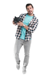Handsome young man with piggy bank on white background