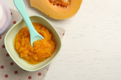 Photo of Baby food. Tasty pumpkin puree on white wooden table, flat lay. Space for text