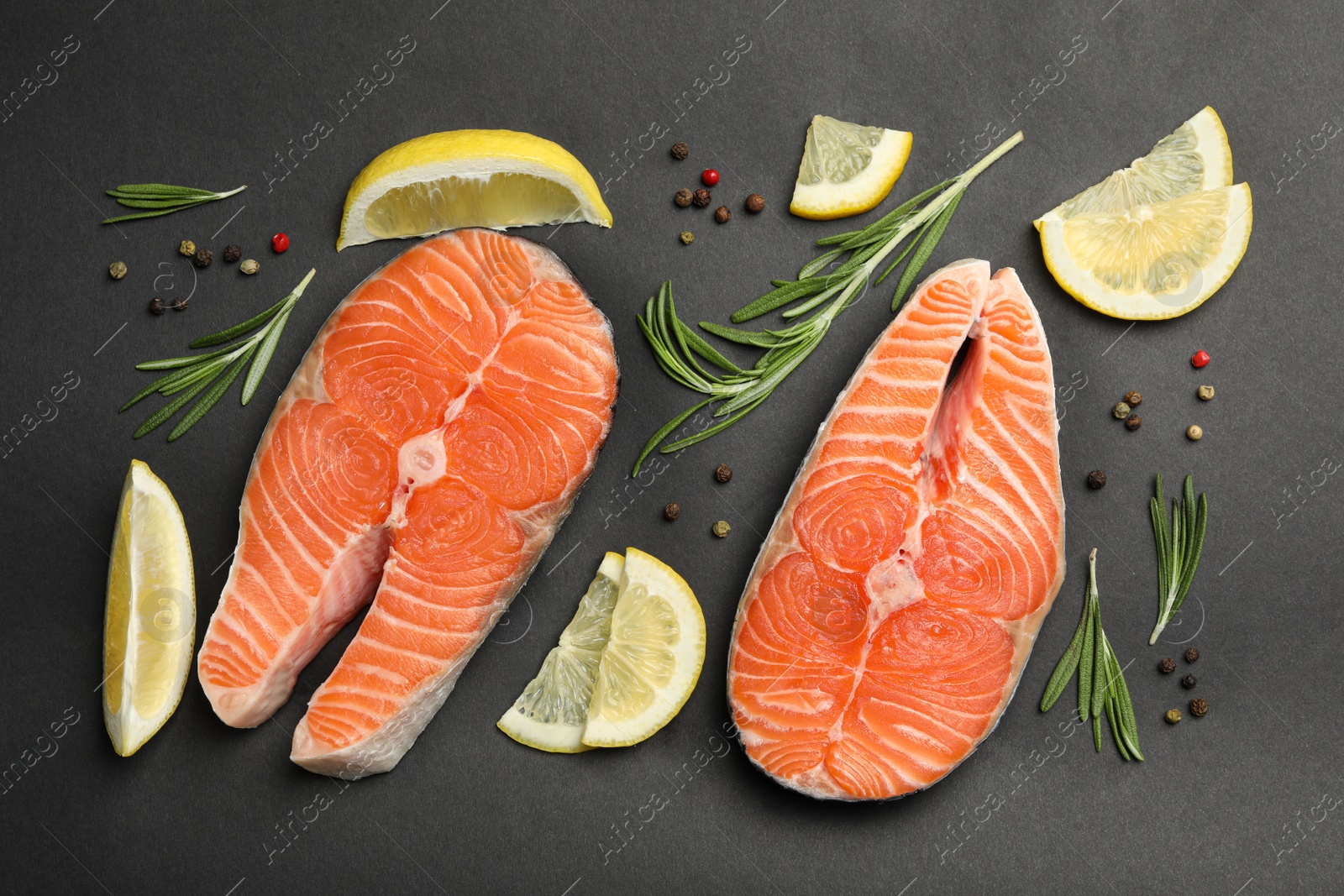 Photo of Flat lay composition with salmon steaks on black background