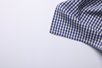 Blue checkered tablecloth on white background, top view