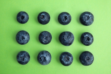 Photo of Fresh ripe blueberries on green background, flat lay