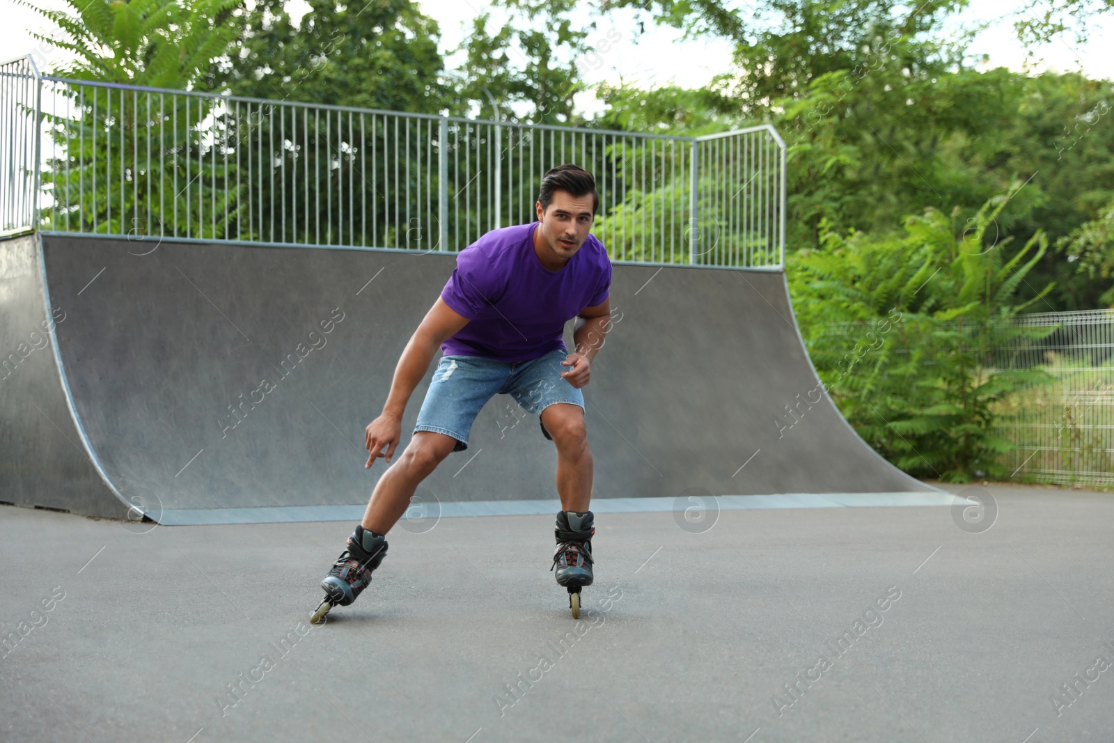 Photo of Handsome young man roller skating in park