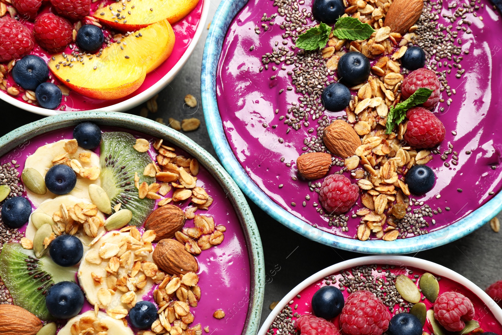 Image of Delicious acai smoothie with toppings in bowls on table, flat lay