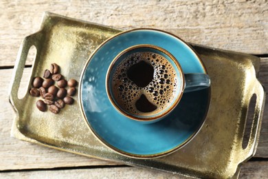 Photo of Turkish coffee. Freshly brewed beverage and beans on wooden table, top view