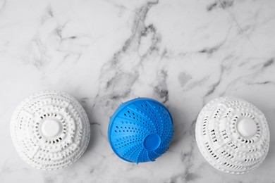 Photo of Laundry dryer balls on white marble table, flat lay. Space for text