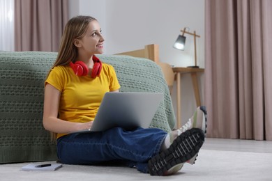 Photo of Online learning. Teenage girl with laptop near bed at home