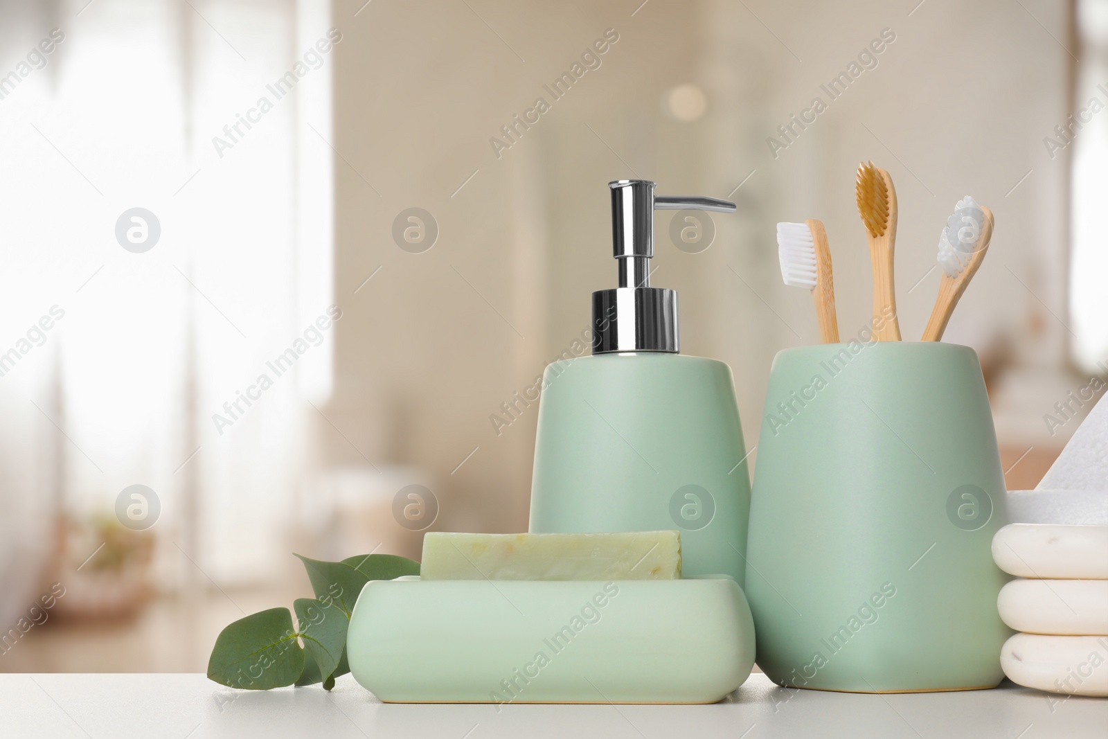 Image of Bath accessories. Different personal care products and eucalyptus leaves on white table in bathroom
