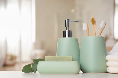 Image of Bath accessories. Different personal care products and eucalyptus leaves on white table in bathroom