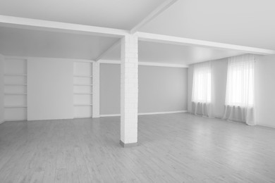 Photo of Empty room with large windows and laminated floor