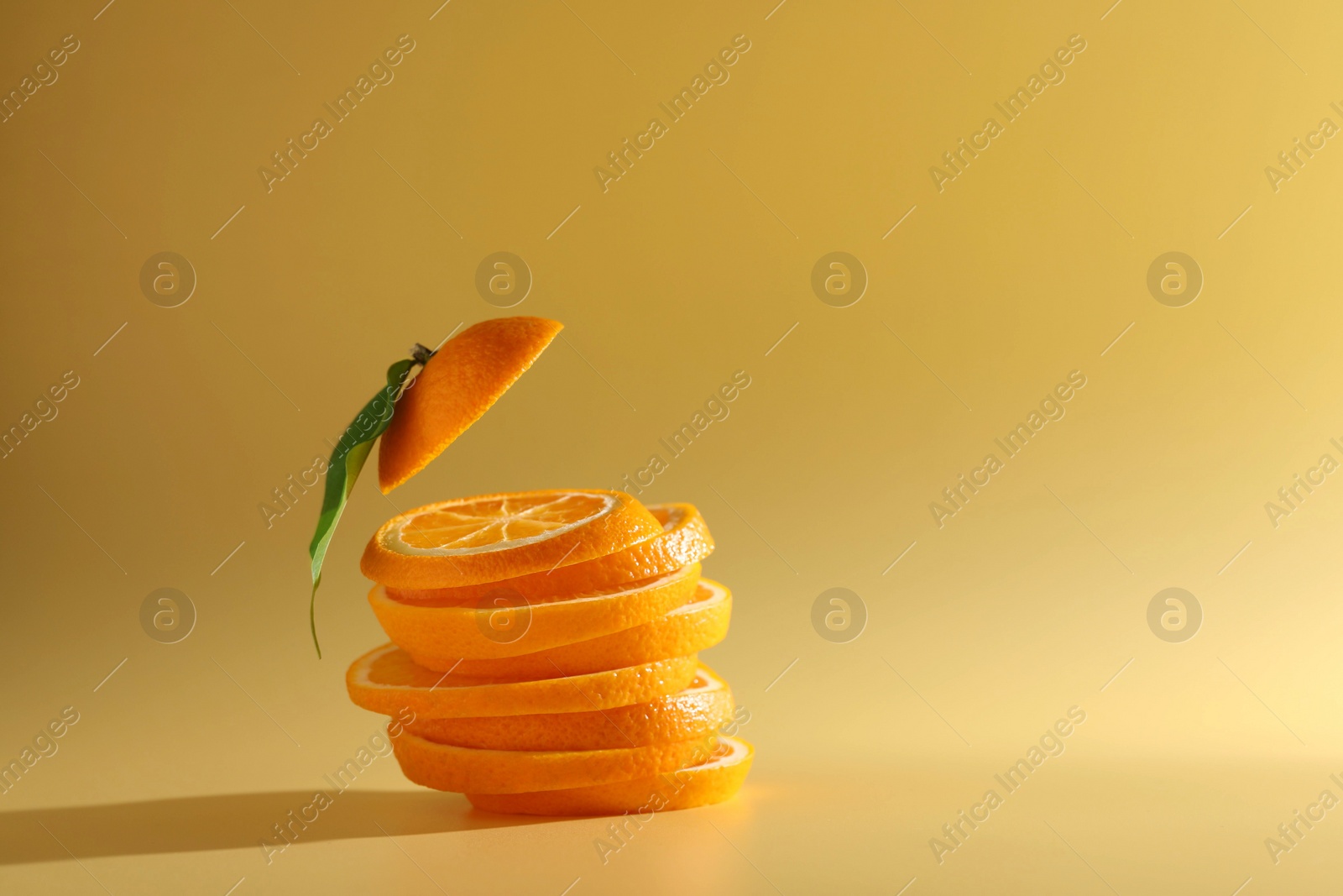 Photo of Slices of juicy orange and leaf on beige background. Space for text